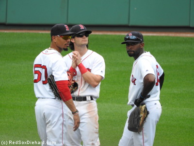 The outfielders discuss important outfielder things during a pitching change.